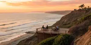 Corporate team on an oceanfront deck at sunset, a great San Diego corporate retreat idea.