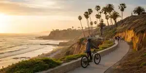 San Diego electric bike tour group riding along a scenic coastal path at sunset.