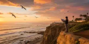 A private tour guide with a map on a scenic San Diego cliff at sunset.